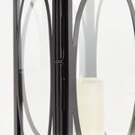 Close-up of black oval frame detail over clear glass with candle interior visible