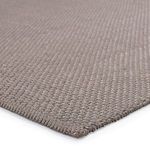 Close-up corner view highlighting thick textured weave and tight edge binding of solid gray rug