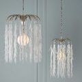 Pair of Glen Arbor pendants lit with warm glow against pale blue paneled wall