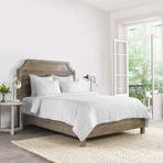 Jayson Linen Cashmere White Duvet on wooden bedframe in bright room with natural light and woven rug