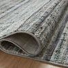 Close-up of rug corner folded over to reveal tight weave and plush polyester pile texture