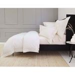 Side view of duvet set showing smooth cotton sateen fabric draping over a black bed frame in neutral room setting