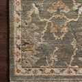 Close-up of runner rug corner showing detailed floral pattern, fringe, and texture on dark hardwood floor