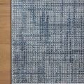 Rug corner lying flat on wooden floor highlighting clean, tight edge binding