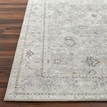 Zoomed-in corner view highlighting the detailed border pattern and rug edge on hardwood floor