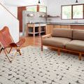 Hagen White Navy Rug styled in modern living room with wood floors and tan leather seating