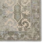 Detailed close-up of rug border highlighting intricate weaving and color variation in sage and light blue