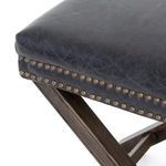 Close-up of brass-finished nail heads lining the bottom edge of the leather cushion