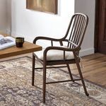 Brenna Dining Chair in dining room from side angle, showing armrest and cushion in room context