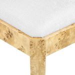 Detailed corner of the chair seat showing white upholstery texture and burl wood frame joinery