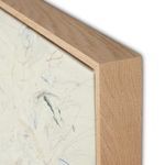 Close-up of painting corner featuring tight grain light wood frame and canvas edge details