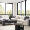 Full room setting with Leone Modular Sectional in Nomad Snow fabric paired with black coffee table and large windows