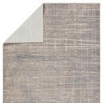 Back side of the rug flipped over revealing light beige fabric backing