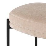 Close-up of almond polyester seat cushion texture and black metal frame corner