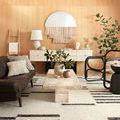 Roman rug shown in living room with beige furniture, black chairs, and greenery