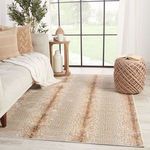 Rug styled in a light living room with beige sofa, throw blanket, pouf, and large window background