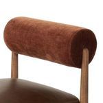 Close-up detail of rust-colored bolstered velvet backrest and oak support posts