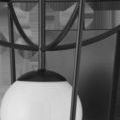 Close-up showing smooth milky white glass globe and curved black metal frame details