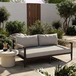 Sherwood sofa in an outdoor garden setting with neutral cushions and surrounding greenery