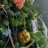 single brown and gold flocked glass ornament hanging on decorated Christmas tree with various other ornaments