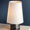 Full front view showing tapered white shade on round dark marble base with brass accents
