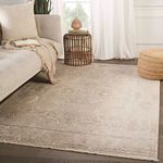 Styled living room with rug under light beige sofa, rattan side table and natural fiber ottoman