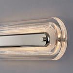 Close-up of polished silver center bar on clear glass frame lit from within