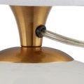 Power cord detail showing transparent cable secured through brass fixture on the lamp base