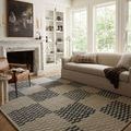 Bradley rug styled in a bright living room under a beige sofa and leather chair