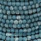 Detailed textured close-up of varying blue mango wood beads on the Rowan Floor Lamp base