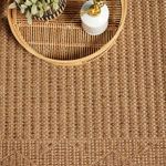 Overhead close-up of rug surface with round rattan tray and white pump bottle