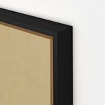 Close-up of raw canvas texture wrapped in a sleek black frame corner with sharp vertical grain