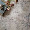 Close-up of Loren Silver Slate Rug's printed textured effect with book and dried flowers on top