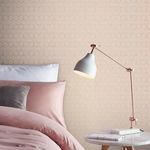 blush textured wallpaper with rose gold hexagon pattern styled in soft pink bedroom setting with white pillow and modern lamp