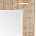 Wall-mounted mirror in a styled room above gold console with various lamps and small side table