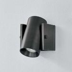 Nowra Wall Sconce angled slightly upward with lit bulb visible in distressed bronze finish