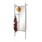Angled view of mirror on wall with tan hat and brown striped scarf hanging from hooks