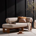 Chaise styled with pillows, throw blanket, and placed in outdoor setting against dark backdrop