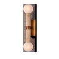 Beatrix Bath Wall Sconce with vertical travertine column, antique brass mounting, and two milky textured art glass globes