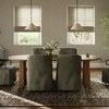Dining room scene with six olive-toned Brently Dining Chairs around wooden oval table