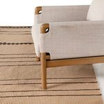 Partial view of cream upholstered sofa with wood frame sitting on Vallarta Brown rug showing rug scale in room context