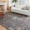 Cassandra Charcoal / Rust Rug shown in living room setting under white sofa with light wood flooring and modern decor