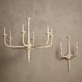 Aleister Wall Sconce displayed beside chandelier on neutral textured wall with warm lighting