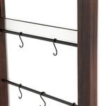 Close-up of black metal bars with S-shaped hooks attached to dark wooden frame