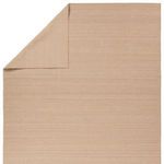 Top corner of rug folded to reveal consistent weaving and underside in solid tan