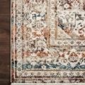 Rug corner detail highlighting refined fringe border and layered pattern on dark wood floor