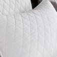 Quilted white cotton pillow with diamond pattern on bed coordinating with Lana quilt