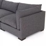 Close-up of sectional corner with overlapping back cushions and well-defined armrest in charcoal fabric