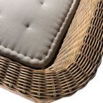 Detailed corner of woven rattan with beige tufted cushion on bench seat