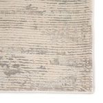 Close-up of rug edge showing detailed woven border and texture variations in gray and ivory